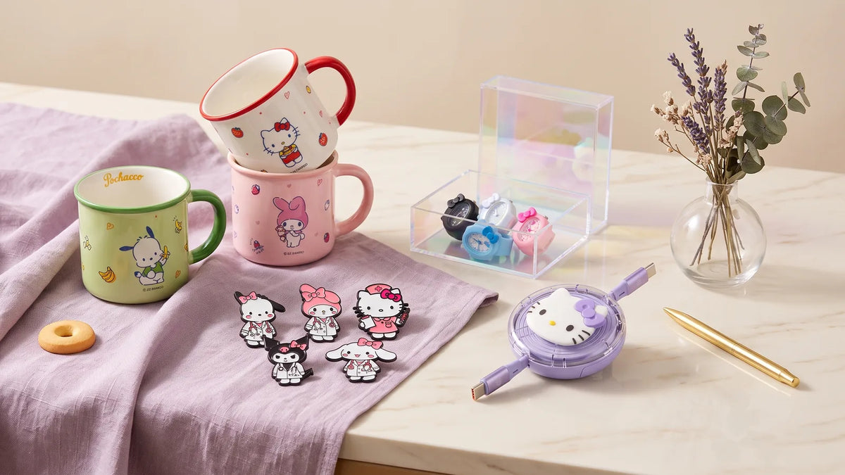 Mugs, pin's, montre-bague et câble Hello Kitty sur un bureau en marbre